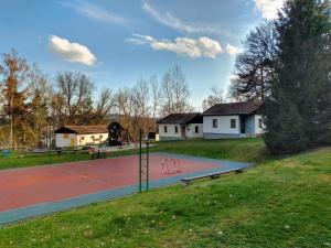 a basketball court in a park with a playground at Chata Nad rybníkem Hnačov 