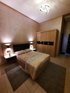 een slaapkamer met een groot bed en 2 tapijten bij اقامة البحتوري in Nador