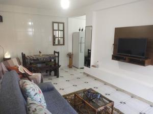 a living room with a couch and a flat screen tv at Pouso Ponte dos Suspiros com Garagem in Ouro Preto