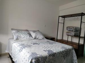 a bedroom with a bed with a blue and white comforter at Pouso Ponte dos Suspiros com Garagem in Ouro Preto