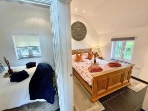a bedroom with a bed and a clock on the wall at The Mermaids Watch Pendine DOG FRIENDLY in Pendine