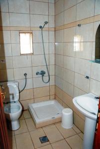 y baño con ducha, aseo y lavamanos. en Avra Apartments, en Limenaria