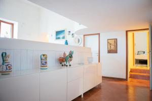 une cuisine avec des placards blancs et des vases sur le comptoir dans l'établissement casa con vista panoramica, à Anacapri
