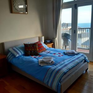 Schlafzimmer mit einem Bett und Meerblick in der Unterkunft Kaia Penthouse, waking up to the sound and smell of the ocean in Ventnor