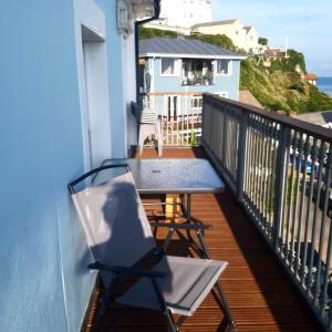 uma mesa e cadeiras numa varanda com o oceano em Kaia Penthouse, waking up to the sound and smell of the ocean em Ventnor