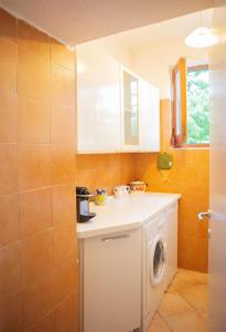 une petite cuisine avec un lave-linge. dans l'établissement casa con vista panoramica, à Anacapri