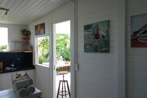 a room with a door and a window and a stool at Héritage créole 2 : Cirik in Sainte-Luce