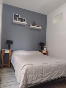 um quarto com uma cama e duas prateleiras na parede em Departamento vista al mar Playa Las Toscas em Mar del Plata
