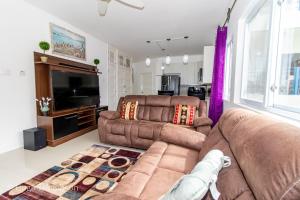 a living room with a couch and a television at THE SPLASHING VIEW in St Mary