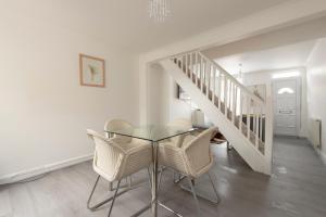 una sala da pranzo con tavolo in vetro e sedie di Beautiful 2 bed house in Grays 4 separate beds sleeps 5 a Grays Thurrock