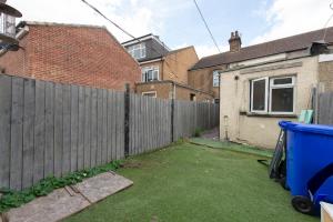 a backyard with a wooden fence and a house at Beautiful 2 bed house in Grays 4 separate beds sleeps 5 in Grays Thurrock