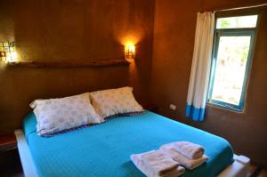 1 dormitorio con 1 cama con toallas en Cabañas AHOPIEDRA, en Vicuña