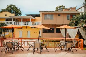 a group of tables and chairs with umbrellas on a patio at Hotel Condesa in Comayagua