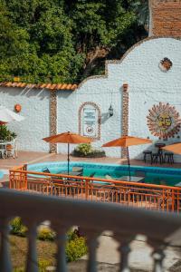 a pool with tables and chairs and umbrellas at Hotel Condesa in Comayagua