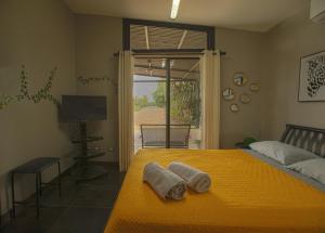 a bedroom with a yellow bed with towels on it at Garden House in Bajo de las Labores