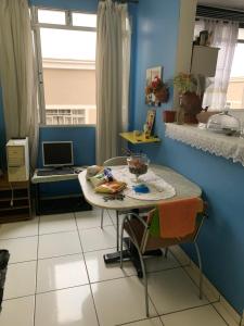 uma cozinha com uma mesa com um computador portátil em Residencial bela vista em Betim