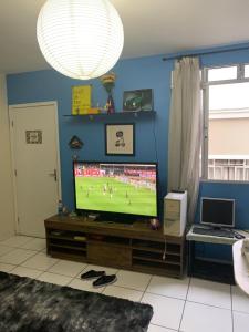 a living room with a tv with a soccer game at Residencial bela vista in Betim