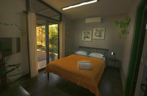 1 dormitorio con 1 cama con manta naranja en Garden House, en Bajo de las Labores