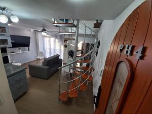 sala de estar con escalera de caracol y sala de estar con sofá en Apartamento dúplex vacacional cerca a la playa, en Gaira