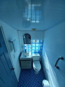 a small bathroom with a toilet and a sink at Apartamento dúplex vacacional cerca a la playa in Gaira