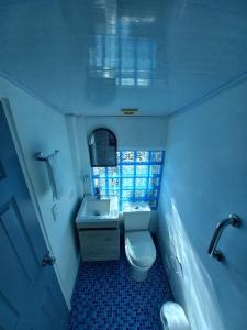 a small bathroom with a toilet and a sink at Apartamento dúplex vacacional cerca a la playa in Gaira +6 photos