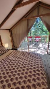 Zelt mit einem Bett und zwei Stühlen auf einer Terrasse in der Unterkunft Dwight Riverside Inn in Dwight