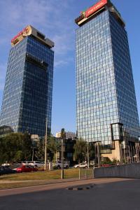 dois prédios altos em um estacionamento com carros na frente em Apartment Marijin Dvor Deluxe em Saraievo