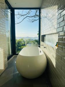 a large white bath tub in a bathroom with a window at Pousada Rio144 in Rio de Janeiro