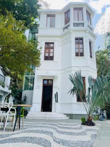 a white house with a black door on a street at Pousada Rio144 in Rio de Janeiro