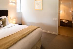 1 dormitorio con 1 cama y ducha a ras de suelo en QS Jade, en Queenstown