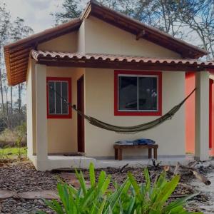 une petite maison avec un hamac en face de celle-ci dans l'établissement Sitio148 Hospedaria, à Penedo
