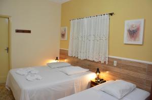 a bedroom with two beds and a window at Hotel Casa Grande in Orlândia