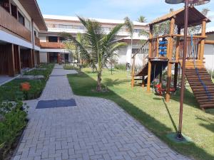um jardim com parque infantil num edifício em Itacimirim - Duplex Aconchegante, Pé na Areia em Itacimirim