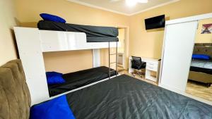 a room with two bunk beds and a desk at Frente para o Mar com Vista Incrível - Porto1003 in Praia Grande