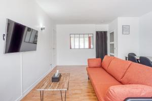 舒瓦西勒魯瓦的住宿－Détente et Confort proche Paris et Orly，客厅配有橙色沙发和桌子