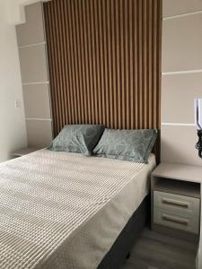 a bedroom with a bed with a wooden headboard at Espaço inteiro Brooklin loft in São Paulo