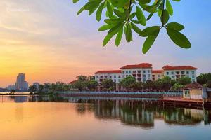 a view of a building on the water at sunset at Hanoi Sunrise Homestay Long Biên in Hanoi