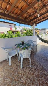 patio ze stołem i krzesłami pod dachem w obiekcie Casa Aconchegante em Arraial w mieście Arraial do Cabo