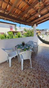 un patio con mesa y sillas bajo un techo en Casa Aconchegante em Arraial, en Arraial do Cabo