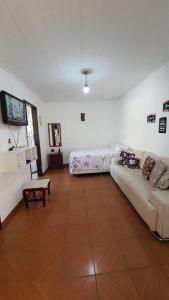 アハイアウ・ド・カボにあるCasa Aconchegante em Arraialのソファとベッドのあるリビングルーム