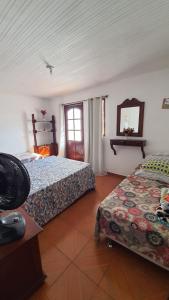 sypialnia z 2 łóżkami i oknem w obiekcie Casa Aconchegante em Arraial w mieście Arraial do Cabo