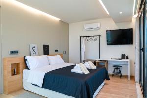 a bedroom with a bed and a desk and a television at The First Key Luxury & small apartment in the center of Xanthi in Xanthi