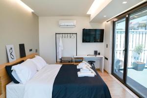 a bedroom with a bed and a desk and a tv at The First Key Luxury & small apartment in the center of Xanthi in Xanthi