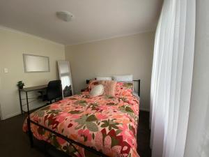 a bedroom with a bed with a red comforter at Invy Escape in Inverloch