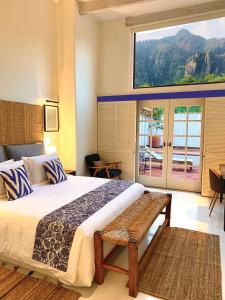 a bedroom with a large bed and a window at Hotel El Ciruelo, Tepoztlán in Tepoztlán