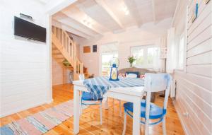 a dining room with a white table and blue chairs at 1 Bedroom Amazing Home In Ustka in Ustka