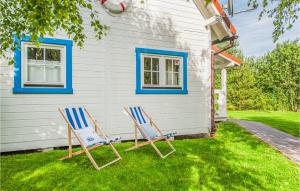 two chairs sitting in the grass in front of a house at 1 Bedroom Amazing Home In Ustka in Ustka