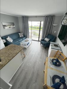 a living room with a blue couch and a table at Sea Chase with an ocean view at Casa Del Mar in Galveston