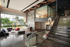 a lobby with a staircase in a building at Thaya Hotel Bangkok in Bangkok