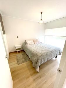 1 dormitorio con 1 cama en una habitación blanca en Apartamento en exclusivo barrio Lomas de san Andrés con estacionamiento en Concepción